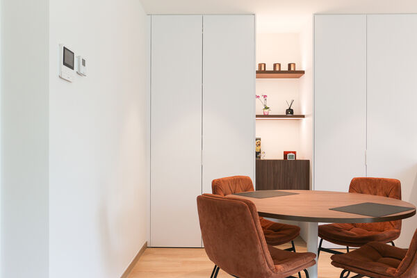 Inbouwkasten op maat rondom een eethoek met ronde tafel, realisatie van Ilwa Maatkasten